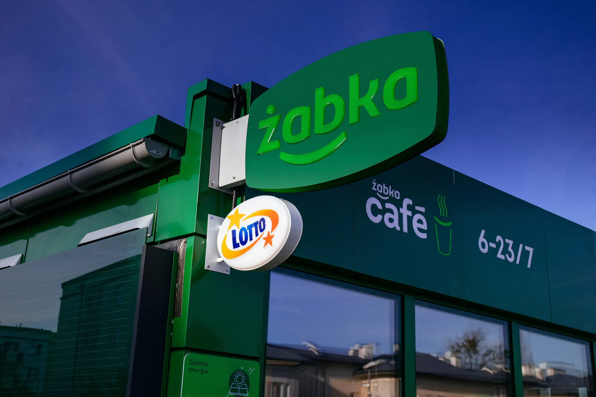 Żabka sklep fasada, utrata pieniędzy grafika, symbol finansowego oszustwa - Oszuści atakują. Na celowniku klienci Żabki