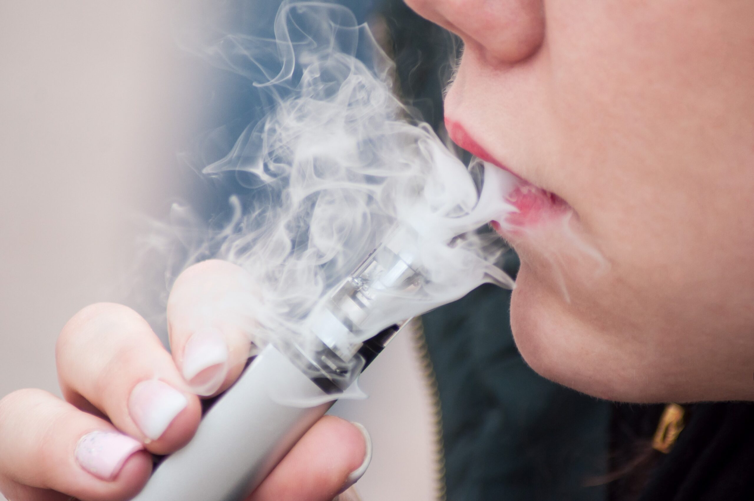 dyskretny e-papieros w dłoni, vape ukryty w ręce, dyskretne palenie w miejscu publicznym, osoba używająca mały e-papieros - E-papierosy pod lupą - jaki naprawdę jest ich wpływ na ...