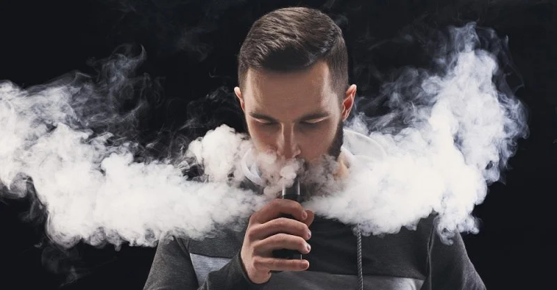 Zadowolona osoba wapująca z e-papierosa Hifancy Super 70000 Puffs, symbolizująca długi czas użytkowania i komfort dzięki deklarowanej liczbie 70000 zaciągnięć.